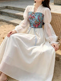 Seated view of blue floral cottagecore maxi dress with ribbon lacing