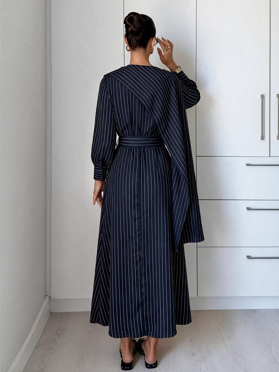 Front view of navy pinstripe belted A-line dress with draped shawl panel and button front