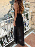 Back view of black open-back tie spaghetti strap maxi dress at seaside balcony
