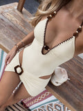 Front view of ivory textured halter one-piece swimsuit with brown trim and draped mini skirt