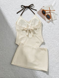 Back view of ivory halter one-piece swimsuit with open back bow and matching draped skirt