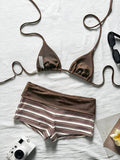 Flat lay of brown halter bikini top and striped high-waist swim shorts