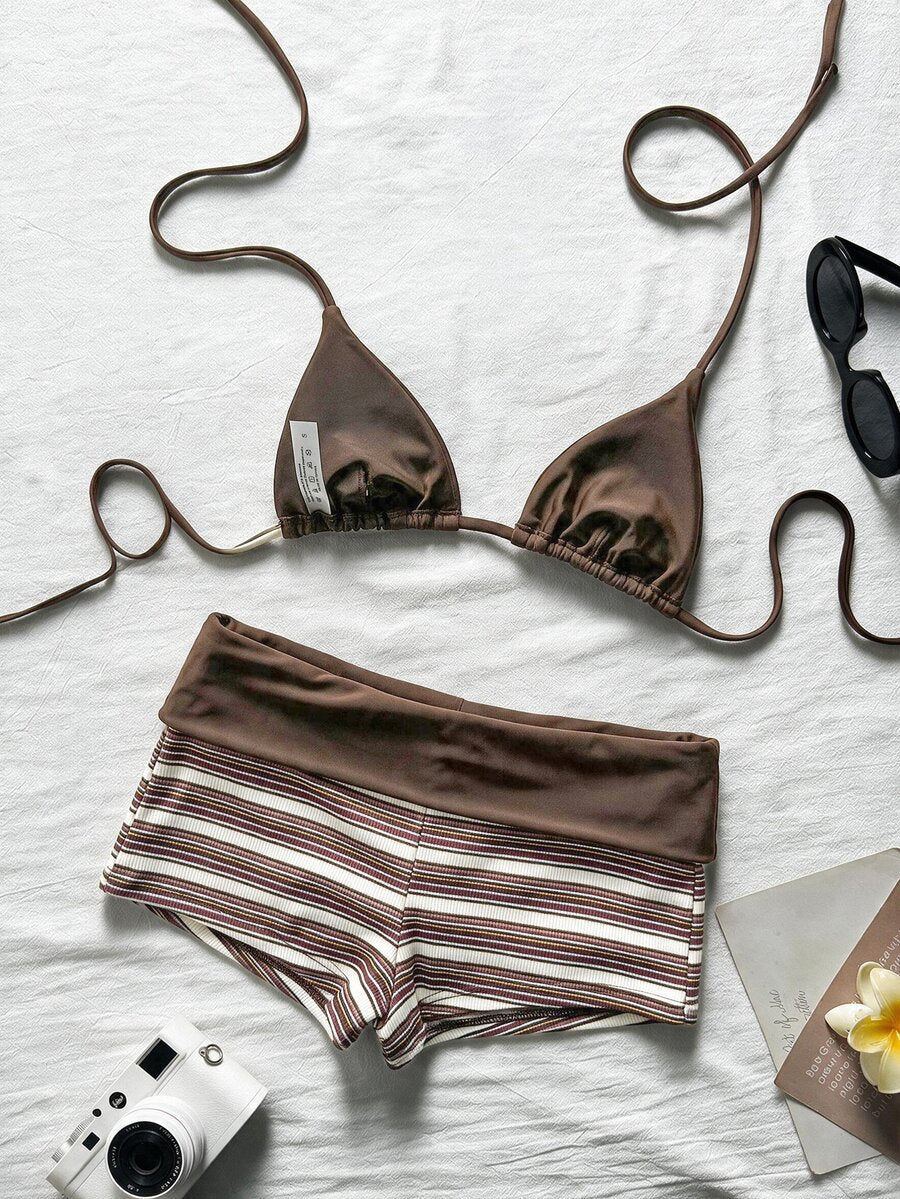 Flat lay of brown halter bikini top and striped high-waist swim shorts