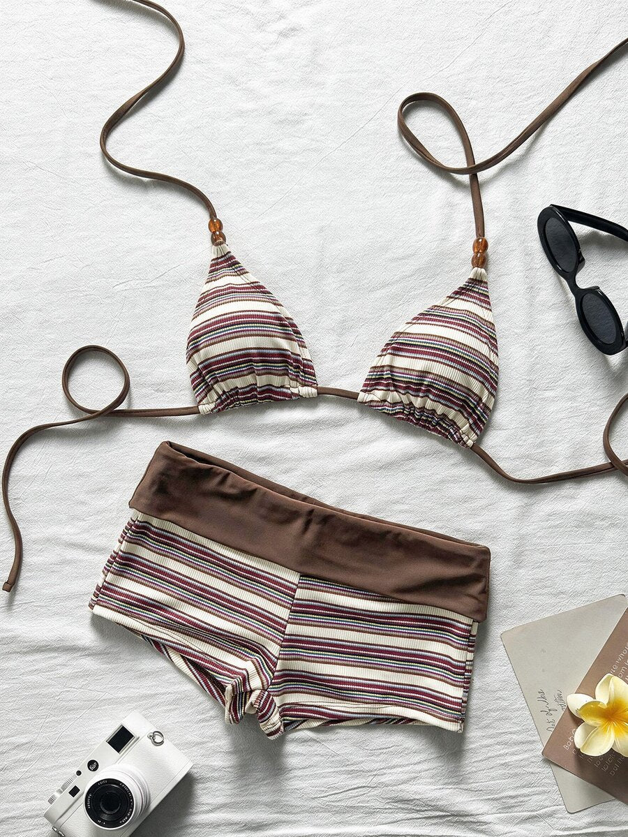 Flat lay of beige brown and purple striped bikini top with matching swim shorts