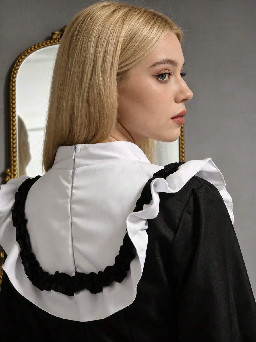 Back close-up of black and white costume showing center zipper and ruffled shoulder yoke