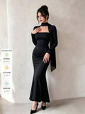 Full view of black ruched waist mermaid midi dress for evening styling