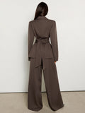 Back view showing sash tie on brown blazer and full-length wide-leg pants