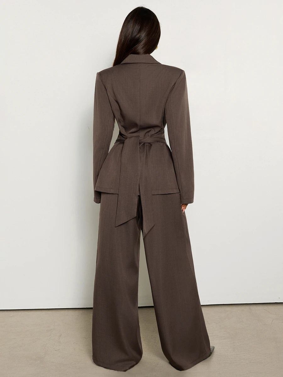Back view showing sash tie on brown blazer and full-length wide-leg pants