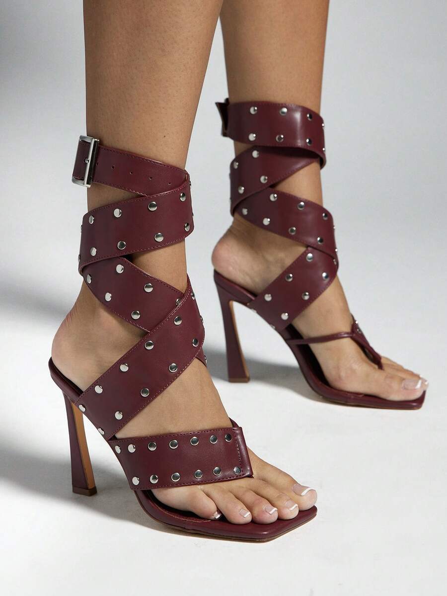 Burgundy studded ankle-wrap high-heel sandals worn by model