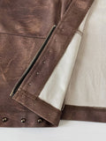Close-up of brown skirt-set fabric showing zipper, stitching and metal studs