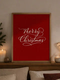 Straight-on view of red Merry Christmas script print displayed on a mantel with candles and holiday greenery