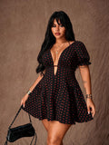 Front view of black dress with red polka dots, deep V-neck, puff sleeves and flared mini skirt