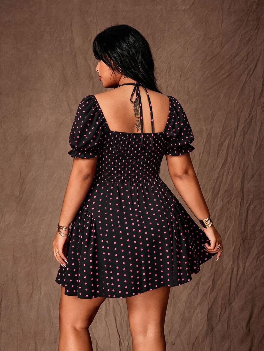 Rear view of black dress with pink polka dots, tie straps, smocked back and flared skirt