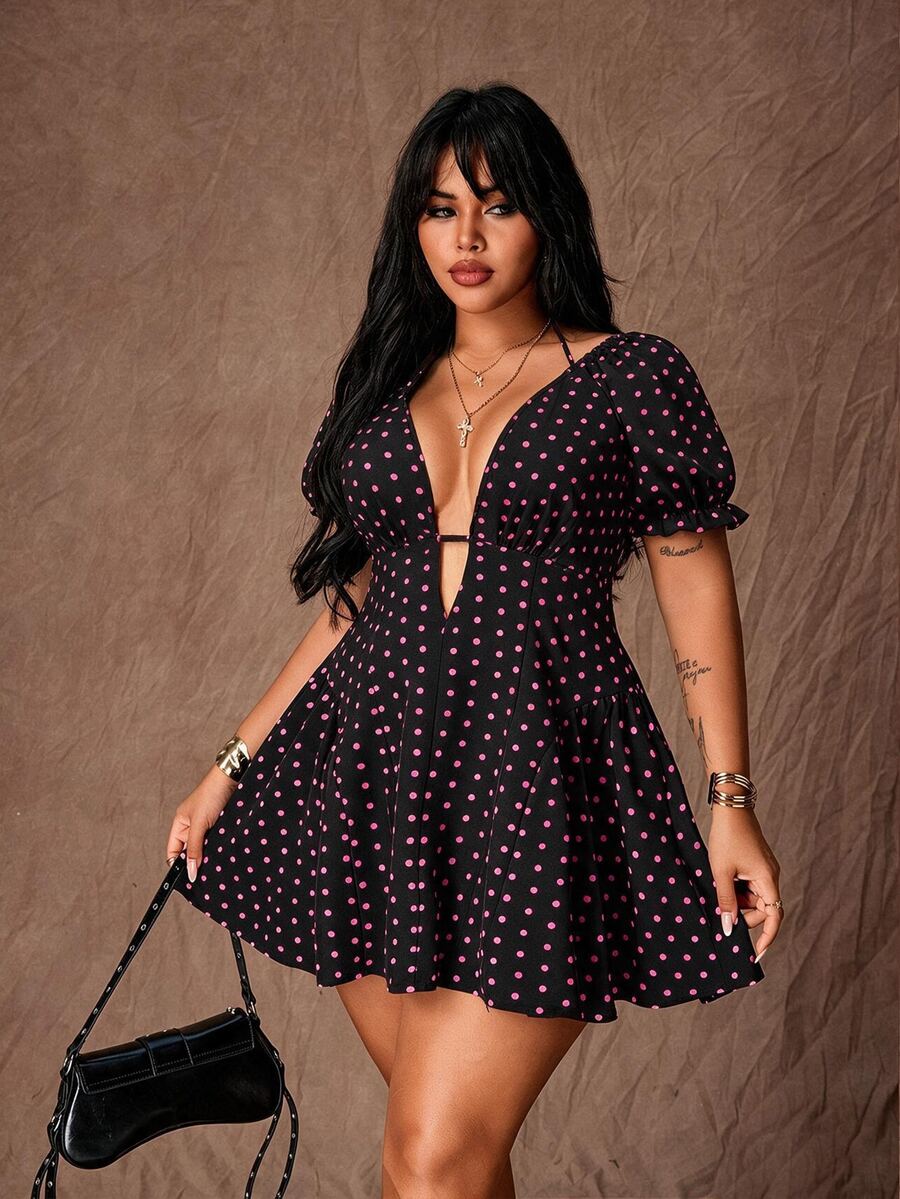 Front view of black dress with pink polka dots, deep V-neck, puff sleeves and flared mini skirt