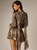 Rear three-quarter view of animal-print mini dress showing long side sash, bell sleeves, and layered ruffle hem