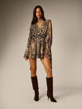 Full-length front view of spotted and zebra-print chiffon wrap mini dress styled with boots