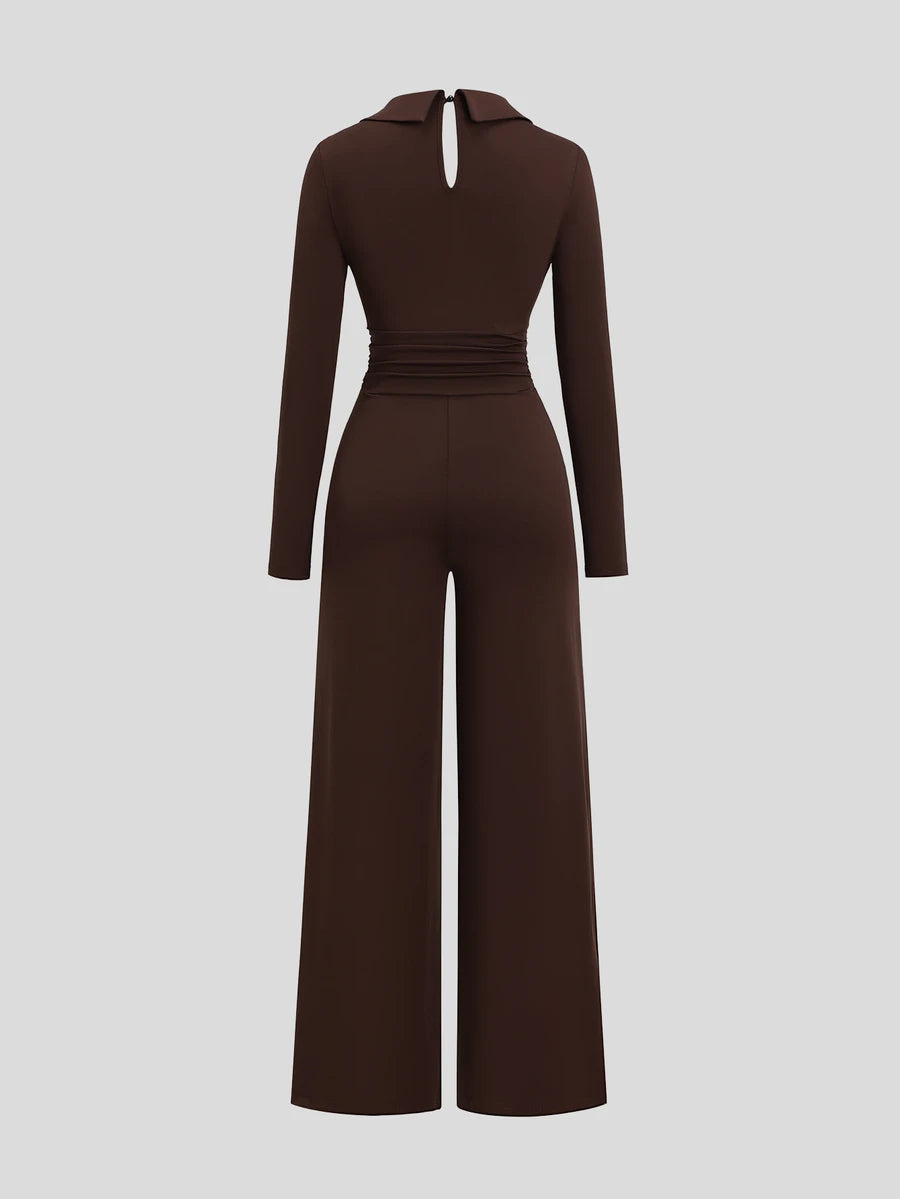 Front view of dark brown collared V-neck jumpsuit with ruched waist and wide legs on studio background