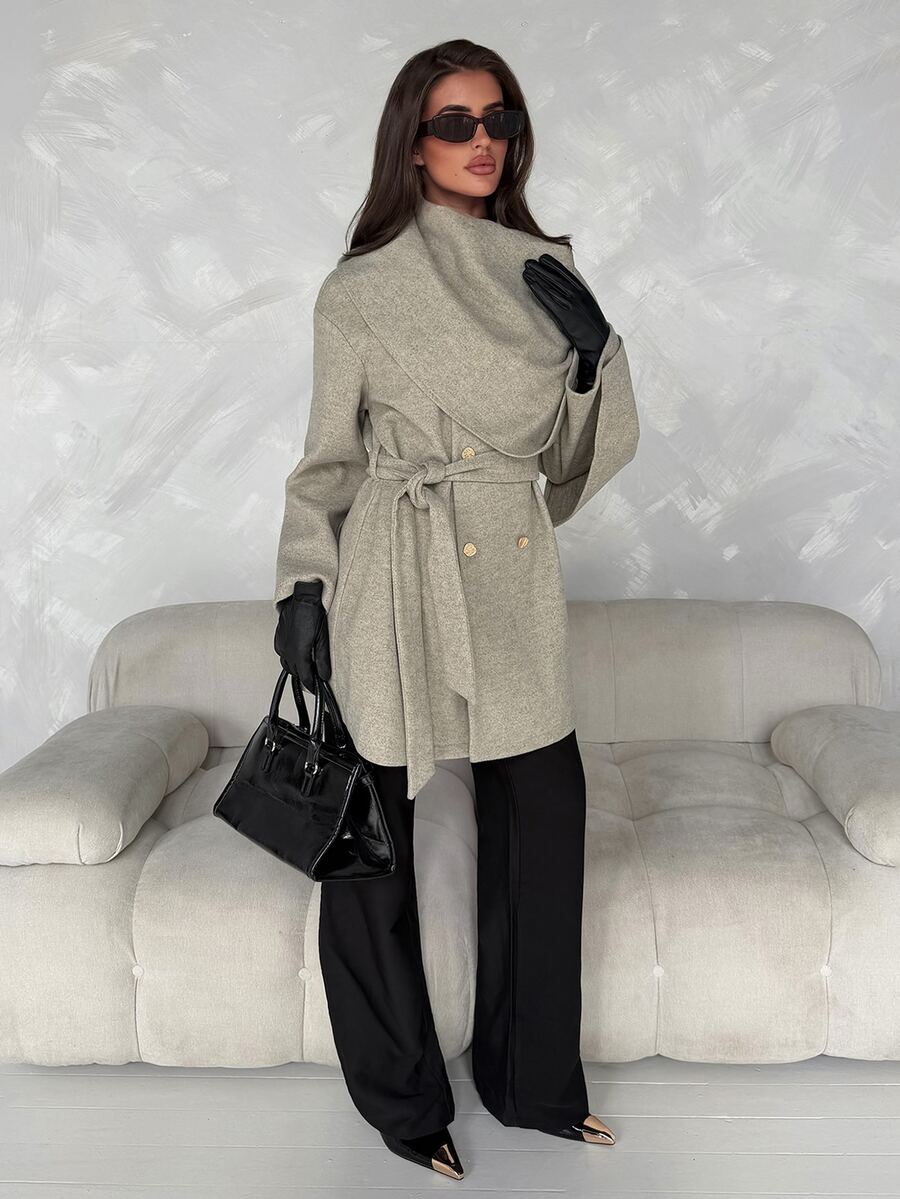 Full-length front outfit view of grey belted wrap coat styled with black trousers, gloves and handbag