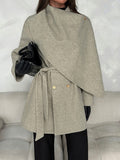 Close view of grey overcoat collar and crossover front with gold-tone button and tied waist belt