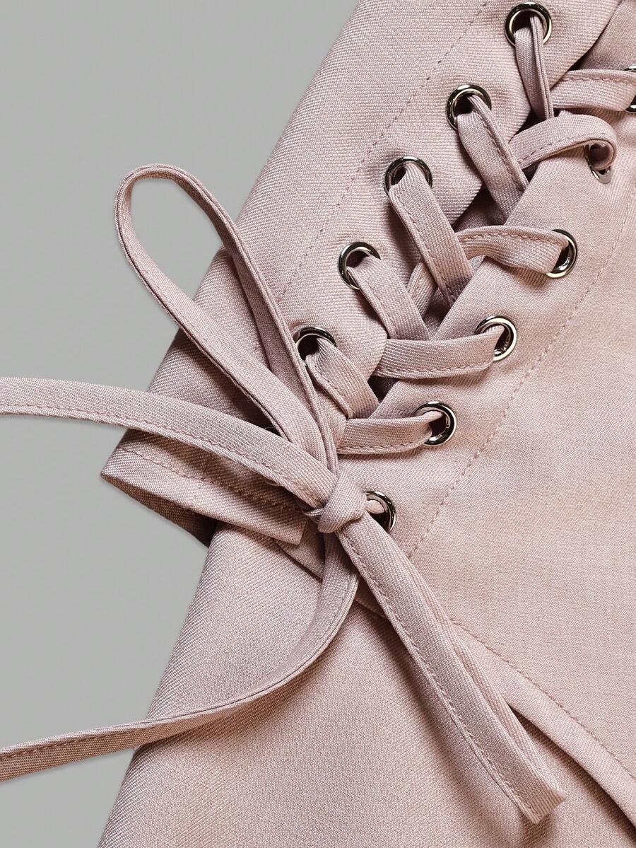 Close-up of dusty pink dress waist panel lacing threaded through metal eyelets