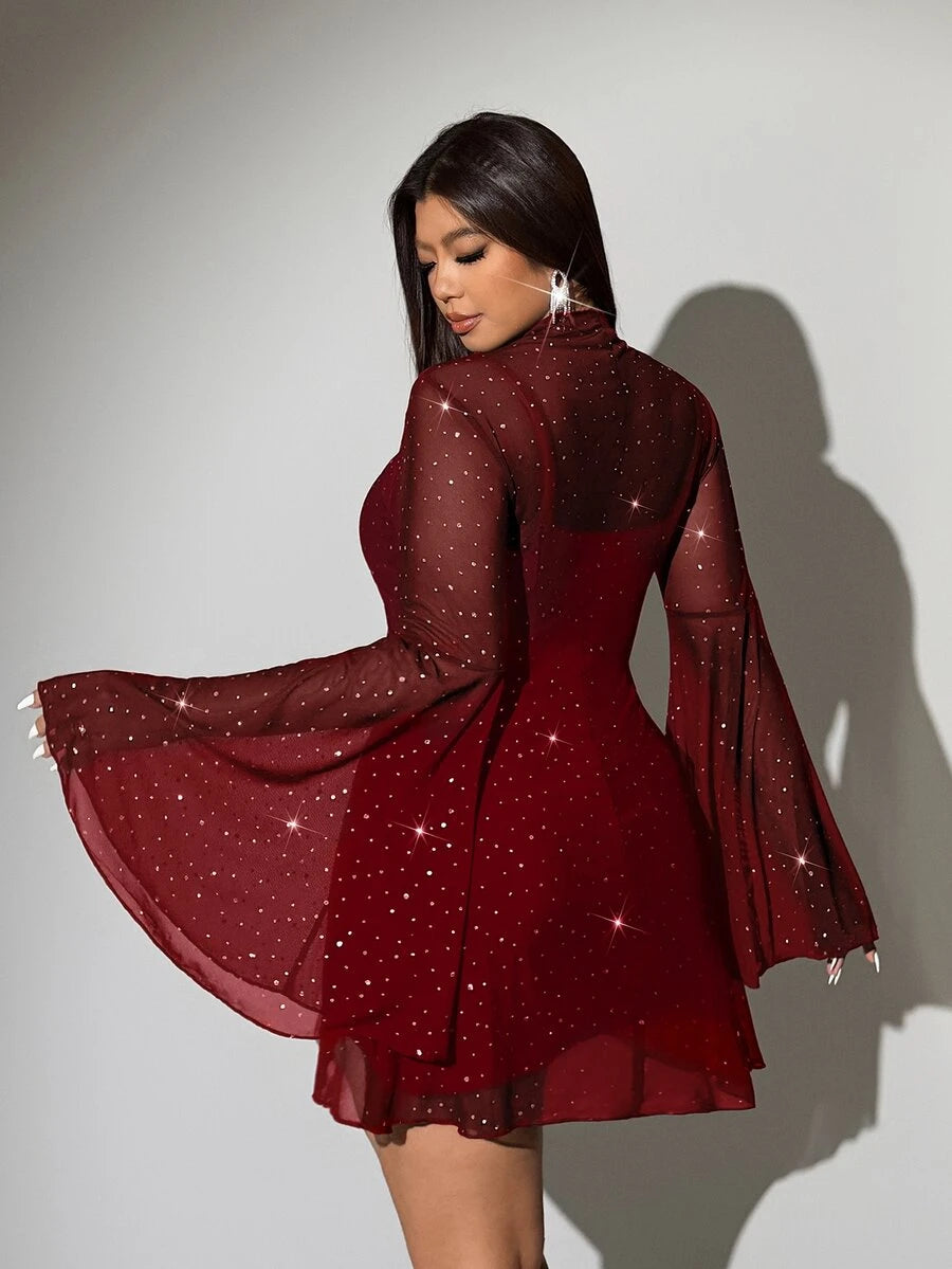 Rear view of red sparkling cover-up mini dress showing sheer sleeves and layered short hem