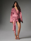 Full-length front view of pink animal-pattern wrap dress with plunging neckline, ruched mini skirt and bell sleeves styled for evening
