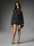 Full-length front view of black stretch-knit mini dress with flowing wide sleeves styled with gold heels