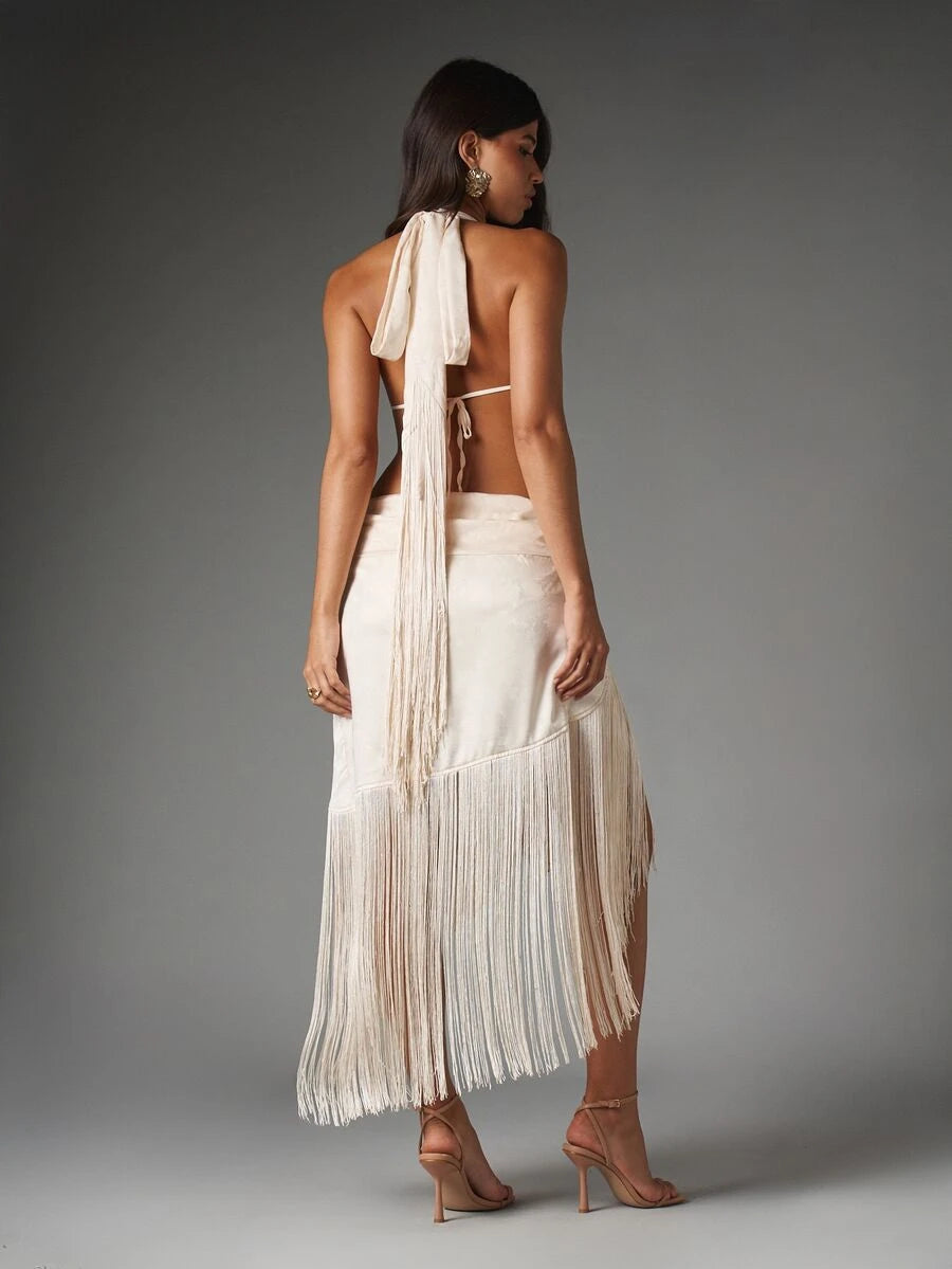 Back view of ivory halter dress showing neck tie, open back, waist band and floor-length fringe