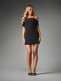 Full-length front view of fitted black off-shoulder mini dress styled with heels
