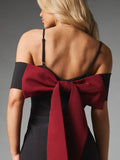 Close-up of open back and large burgundy statement bow on black mini dress