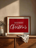 Red and white Merry Christmas typography canvas styled on a wooden console with neutral decor