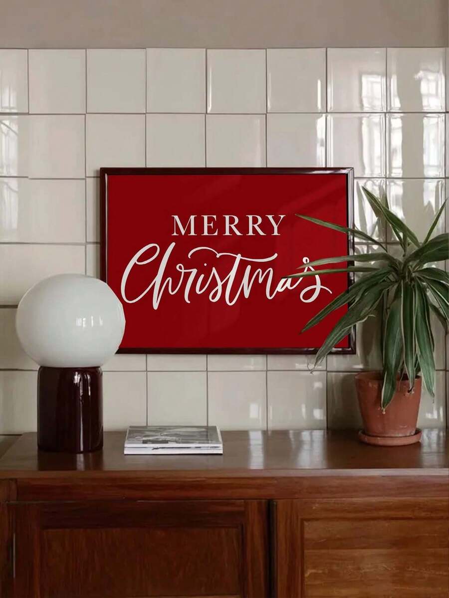 Merry Christmas red canvas print with white lettering displayed against a tiled wall beside a potted plant