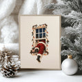 Framed Santa climbing through a lit window print among snowy evergreen branches and ornament