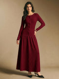 Front view of a burgundy textured long-sleeve maxi dress with round neckline, front buttons, fitted waist, and flared skirt