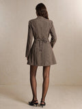 Back view of khaki houndstooth mini dress showing waist tie and flared skirt for fall styling