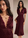 Burgundy polka-dot midi dress close-up showing lace neckline and center cutout
