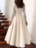 Back view of an ivory full-skirt dress showing floral lace long sleeves and a lace upper-back panel.