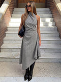 Three-quarter view of the light gray plaid dress with high neck, fitted waist and draped asymmetrical skirt.