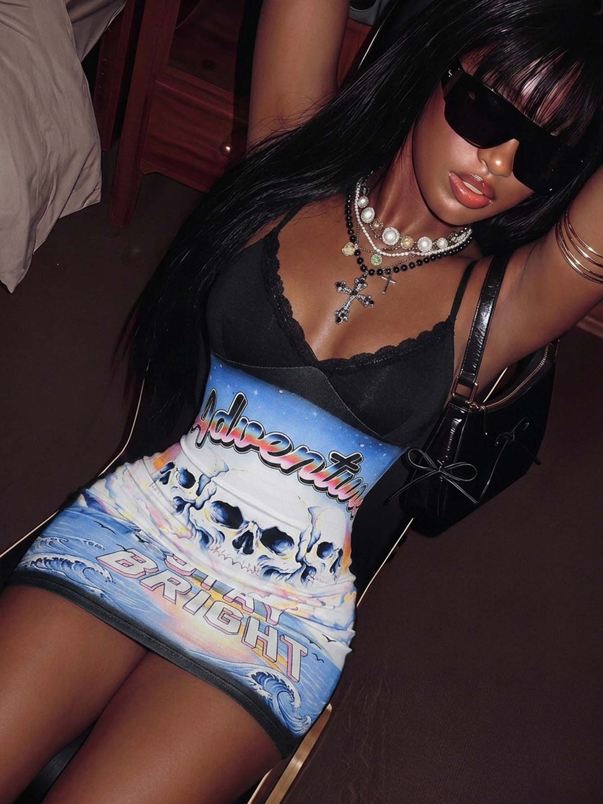 Model wearing black cami mini dress with colorful skull graphic front panel