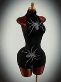 Angled front view of black rhinestone spider halter romper