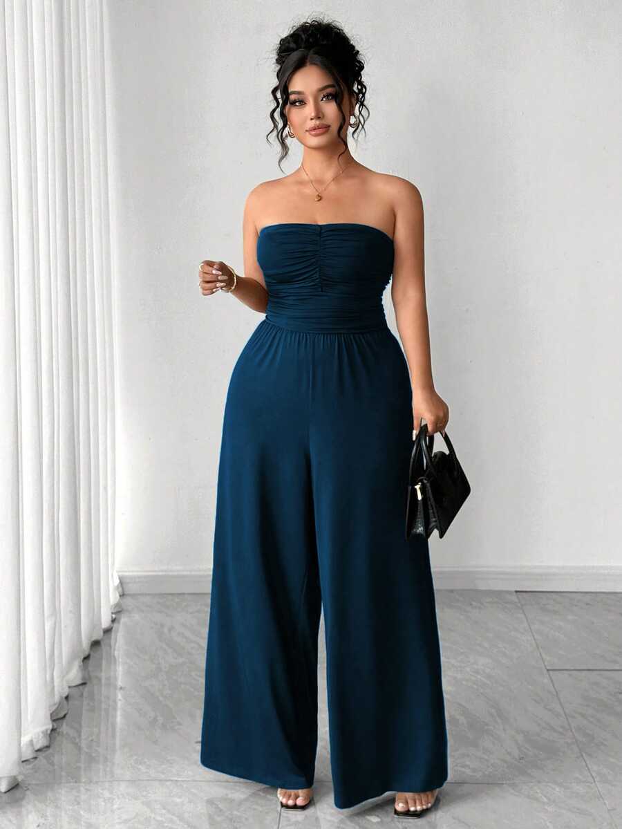Model wearing navy jumpsuit, showing gathered strapless bodice and trousers