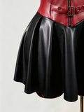Close-up of black faux leather flared skirt beneath red buckle corset waist