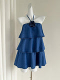 Front mannequin view of blue 3D rose halter denim mini dress with three flowing ruffle tiers