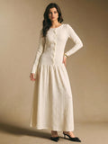 Front view of an ivory white textured long-sleeve maxi dress with button front, fitted bodice, and flared skirt