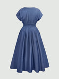 A blue A-line dress with short cap sleeves, a smocked waist, and a gathered back, shown from the back on a light gray background.