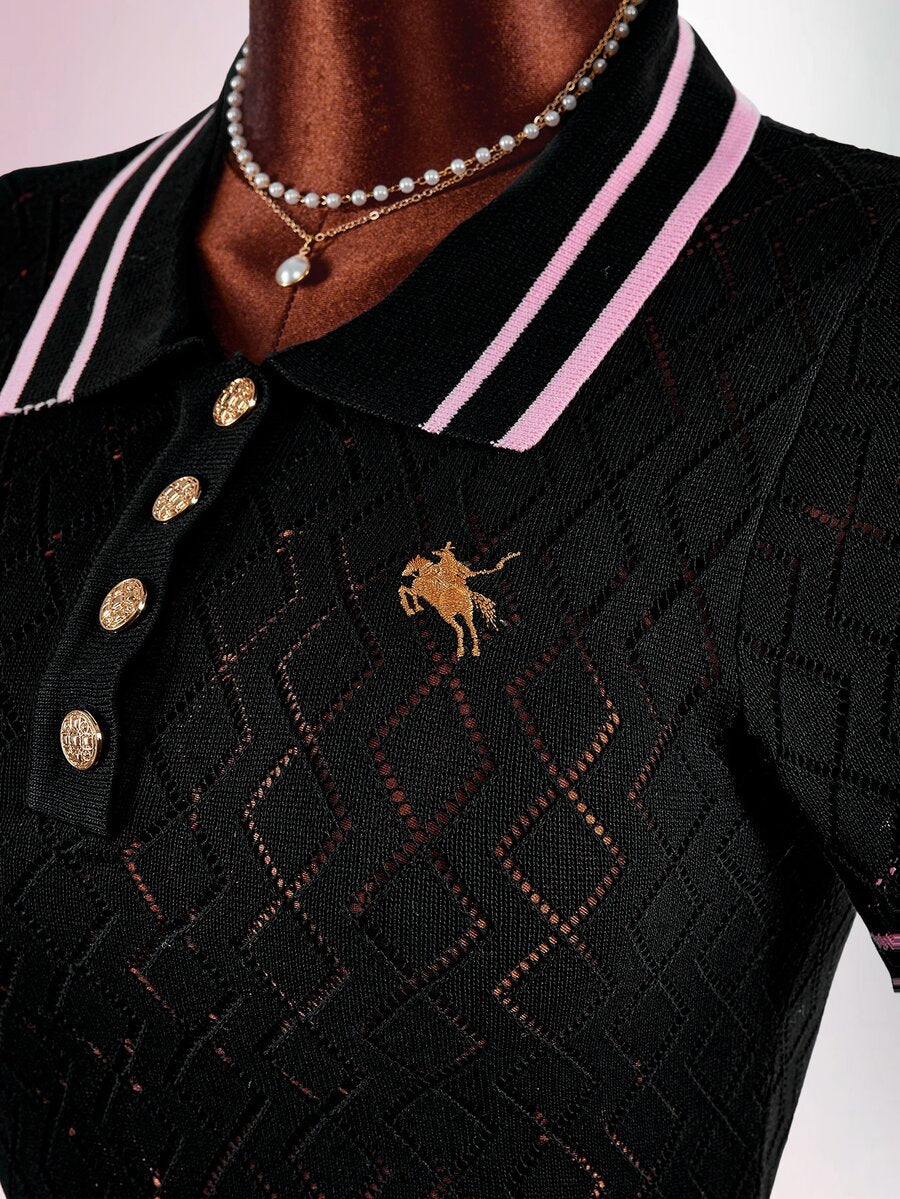 Close-up of black knit dress bodice with pink-striped polo collar, gold buttons, horse embroidery, and geometric openwork
