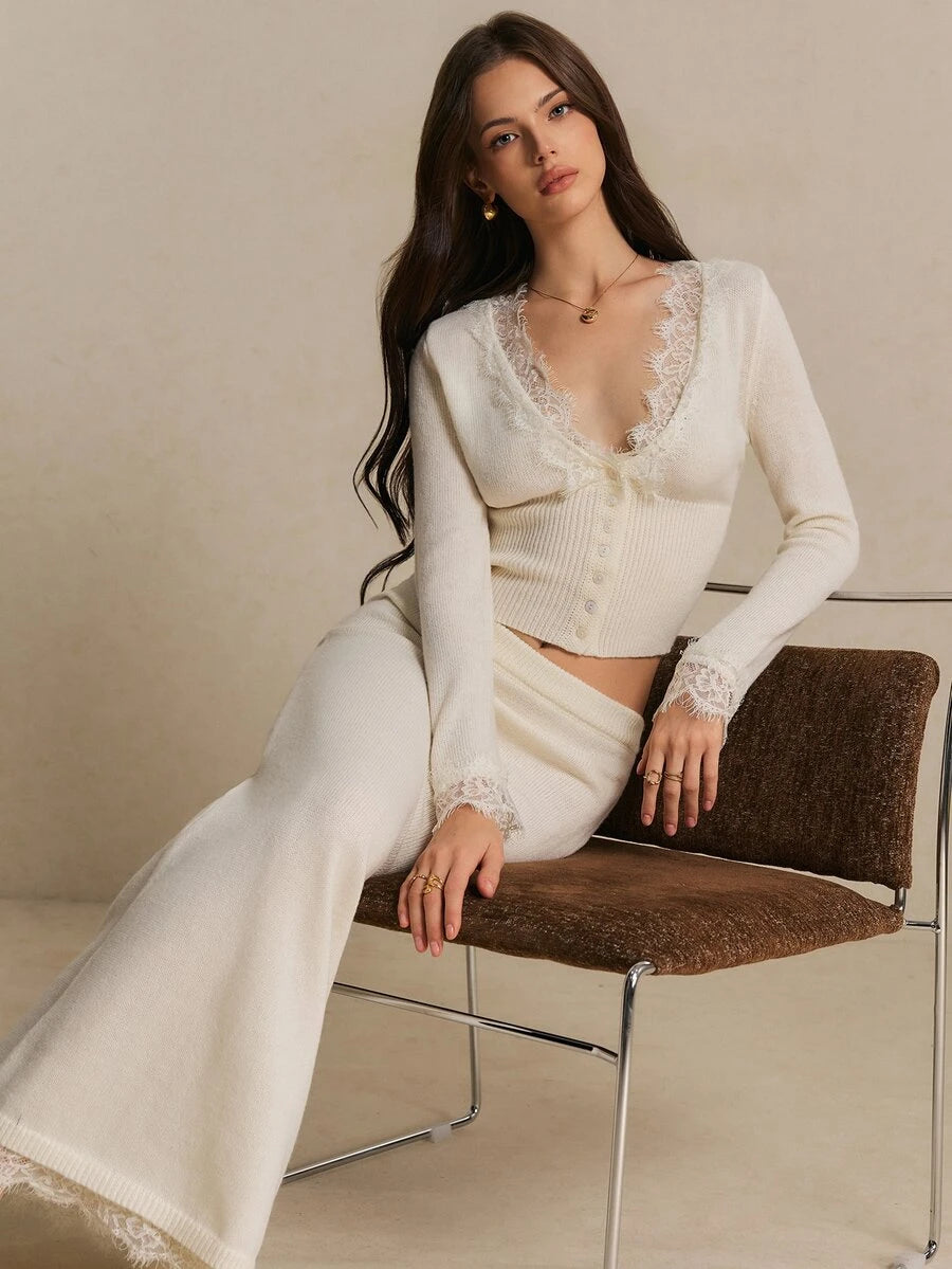 Close-up of floral lace edging at the ivory cardigan neckline and sleeve cuff