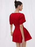 Back view of red puff sleeve mini dress showing center zipper and flared skirt