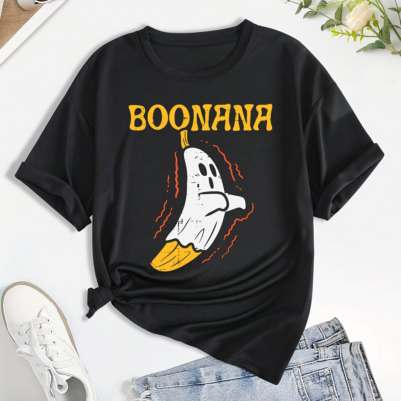 Get ready for Halloween with our Boo-Nana Graphic Tee for women! Made with soft cotton and a comfortable crew neck design, this shirt is perfect for all your spooky festivities. The fun graphic features a playful spin on the classic banana, adding a unique and festive touch to your holiday wardrobe. Order yours today and join in on the Halloween fun!