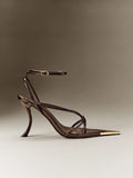 Side profile of chocolate-brown open-toe sandals showing curved stiletto heel and crossed straps